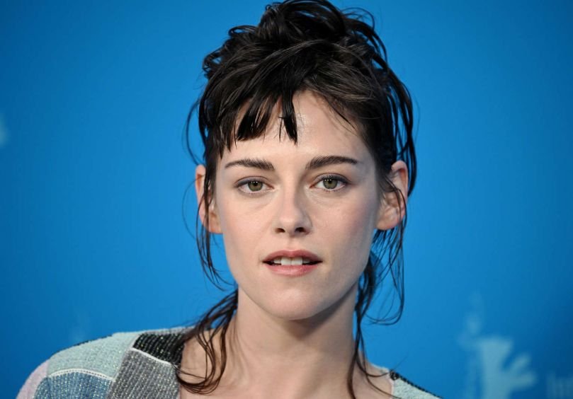 Kristen Stewart en un evento de cine independiente, con expresión seria y mirada intensa, vestida de forma andrógina y elegante.
