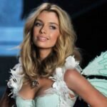 Stella Maxwell caminando en pasarela con atuendo de alta costura y expresión segura.